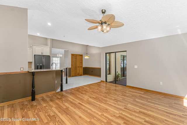 523 Hidden Hollow Dr, Merritt Island, FL 32952 - unfurnished living room with a ceiling fan, plenty of natural light, a textured ceiling, and light wood-type flooring