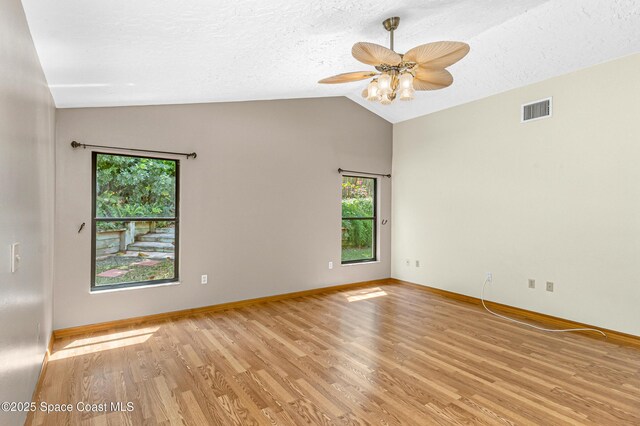 523 Hidden Hollow Dr, Merritt Island, FL 32952 - unfurnished room with a textured ceiling, visible vents, a ceiling fan, light wood-style floors, and vaulted ceiling