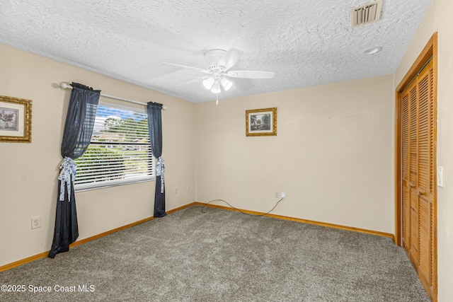 523 Hidden Hollow Dr, Merritt Island, FL 32952 - unfurnished bedroom with a closet, a textured ceiling, baseboards, visible vents, and carpet