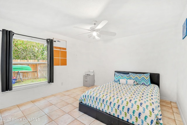 tiled bedroom featuring ceiling fan and baseboards