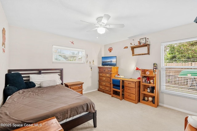 bedroom featuring light colored carpet, a ceiling fan, and baseboards