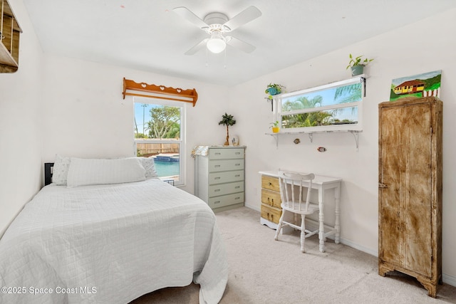 bedroom featuring baseboards, light carpet, and ceiling fan