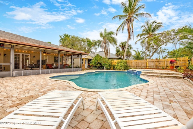view of pool with ceiling fan, french doors, a fenced backyard, and a patio area