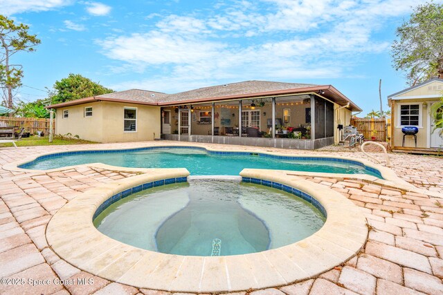 view of swimming pool with a sunroom, a patio, a fenced in pool, a fenced backyard, and an in ground hot tub