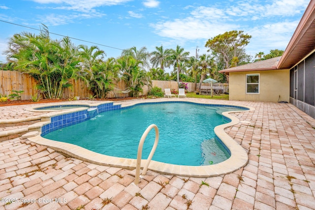 view of swimming pool with a sunroom, a patio area, a fenced in pool, a fenced backyard, and an in ground hot tub