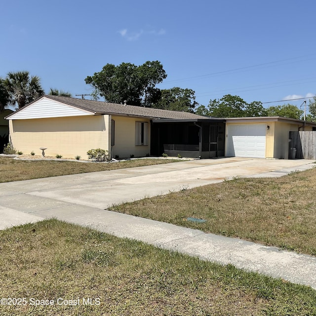 single story home featuring a sunroom, driveway, and an attached garage