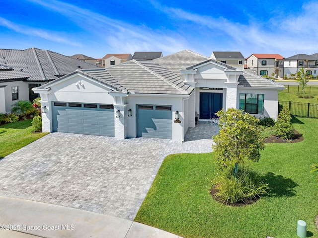 view of front of house with an attached garage, a front lawn, and decorative driveway