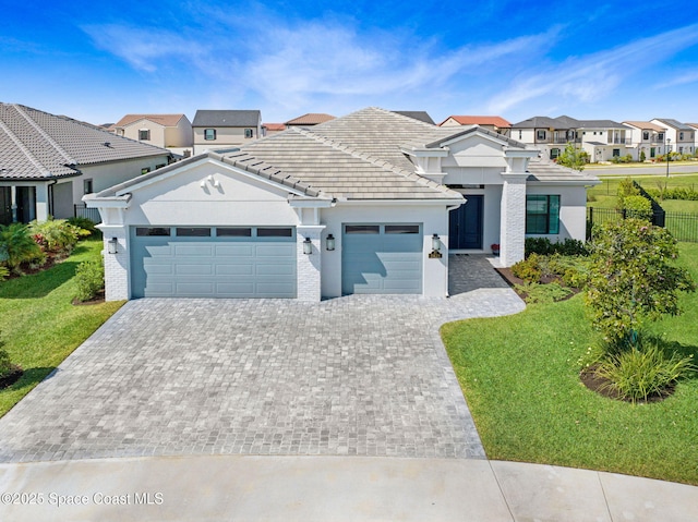 view of front of home featuring a front yard, driveway, fence, and an attached garage