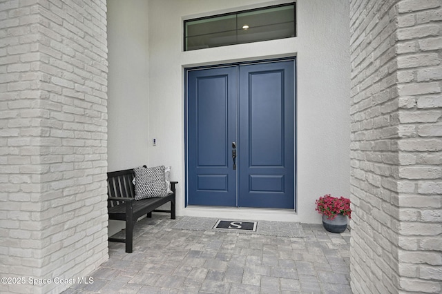 property entrance featuring french doors and stucco siding