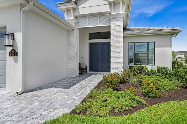 entrance to property featuring stucco siding and a garage