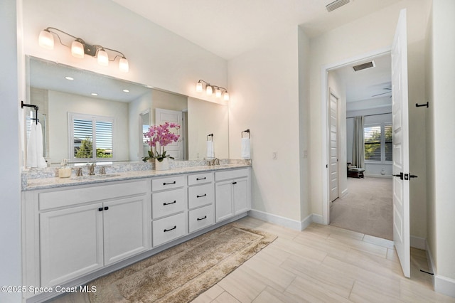bathroom featuring double vanity, visible vents, and a sink
