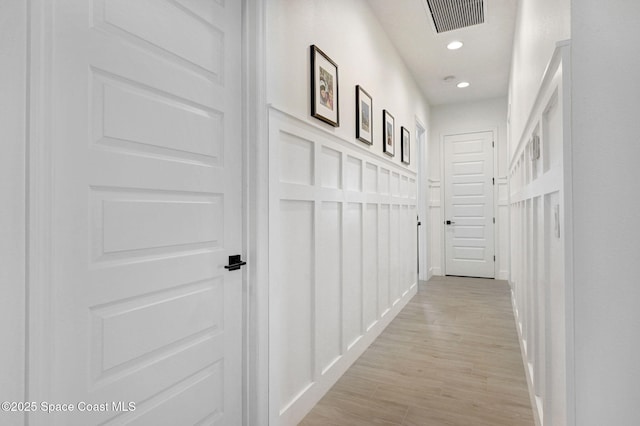 hall with light wood finished floors, visible vents, and recessed lighting