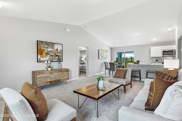 living room with baseboards, lofted ceiling, light colored carpet, and recessed lighting