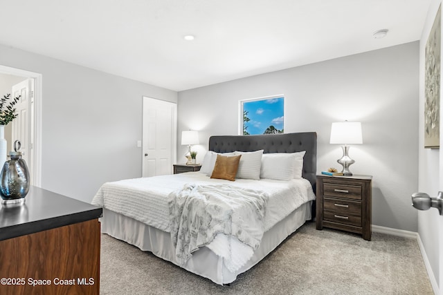 bedroom featuring light colored carpet and baseboards
