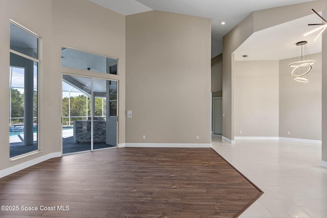 706 Palmer Way, Melbourne, FL 32940 - spare room with high vaulted ceiling, baseboards, wood finished floors, recessed lighting, and a chandelier