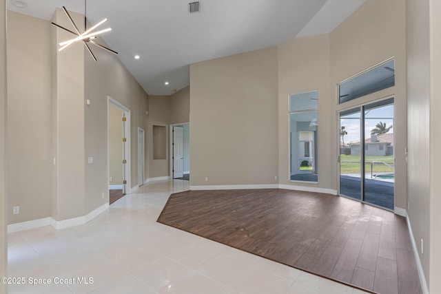 706 Palmer Way, Melbourne, FL 32940 - unfurnished room with a high ceiling, baseboards, recessed lighting, and wood finished floors