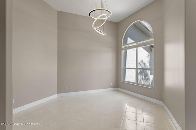 706 Palmer Way, Melbourne, FL 32940 - empty room with light tile patterned floors, a chandelier, and baseboards