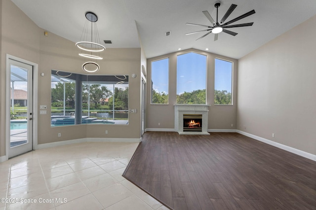 706 Palmer Way, Melbourne, FL 32940 - unfurnished living room featuring vaulted ceiling, a lit fireplace, healthy amount of natural light, and baseboards