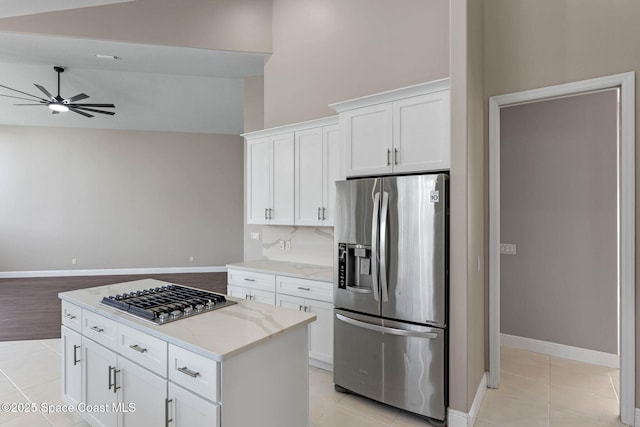 706 Palmer Way, Melbourne, FL 32940 - kitchen with stainless steel appliances, a ceiling fan, light tile patterned floors, white cabinets, and baseboards