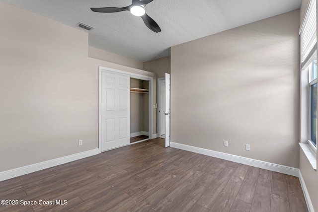 706 Palmer Way, Melbourne, FL 32940 - unfurnished bedroom featuring dark wood-style flooring, baseboards, a closet, ceiling fan, and a textured ceiling