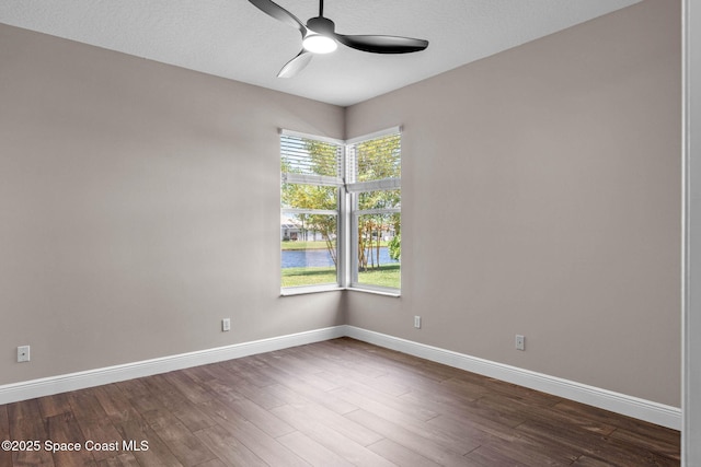 706 Palmer Way, Melbourne, FL 32940 - empty room featuring ceiling fan, baseboards, a water view, and dark wood-style floors