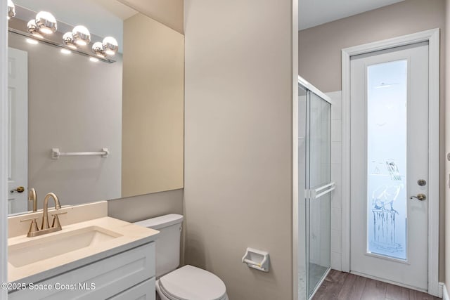 706 Palmer Way, Melbourne, FL 32940 - bathroom with a shower stall, toilet, vanity, and wood finished floors