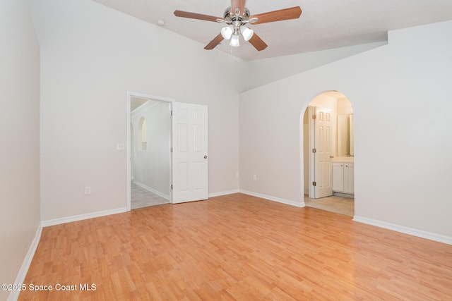 2728 Maderia Cir, Melbourne, FL 32935 - unfurnished bedroom with baseboards, vaulted ceiling, light wood-style flooring, ensuite bathroom, and arched walkways