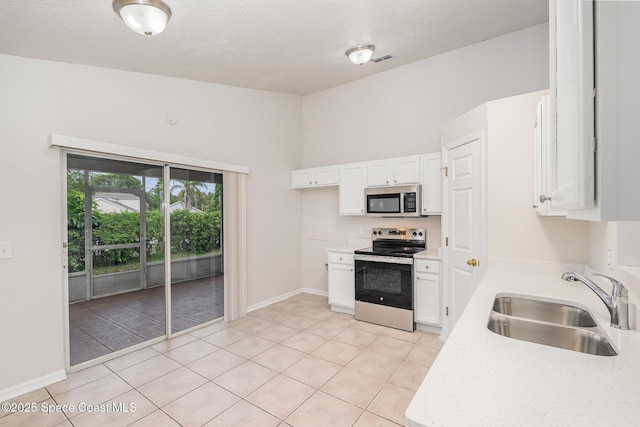 2728 Maderia Cir, Melbourne, FL 32935 - kitchen featuring light tile patterned floors, light countertops, white cabinets, appliances with stainless steel finishes, and a sink