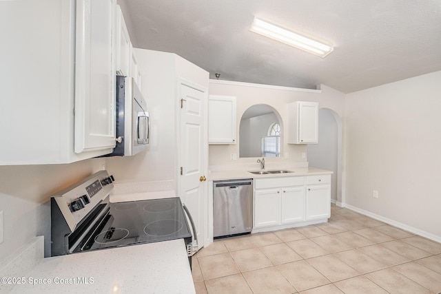 2728 Maderia Cir, Melbourne, FL 32935 - kitchen with arched walkways, white cabinetry, appliances with stainless steel finishes, light countertops, and a sink