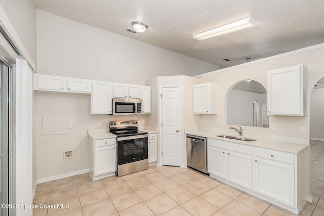2728 Maderia Cir, Melbourne, FL 32935 - kitchen featuring light countertops, white cabinetry, stainless steel appliances, arched walkways, and a sink