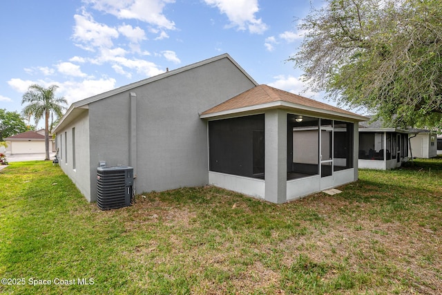 2728 Maderia Cir, Melbourne, FL 32935 - rear view of house featuring roof with shingles, stucco siding, cooling unit, a yard, and a sunroom