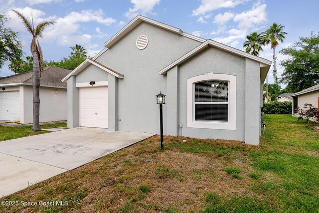 2728 Maderia Cir, Melbourne, FL 32935 - view of front of property featuring a garage, a front yard, stucco siding, and concrete driveway