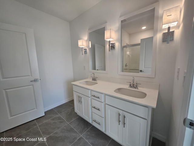 bathroom with double vanity, a sink, tile patterned floors, and a shower stall