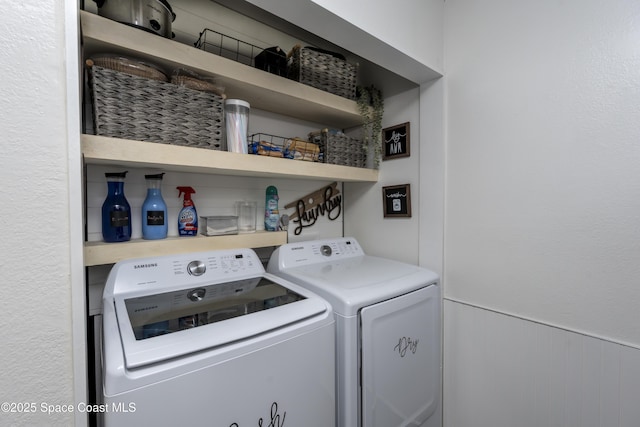 laundry room featuring a wainscoted wall, washer and dryer, and laundry area