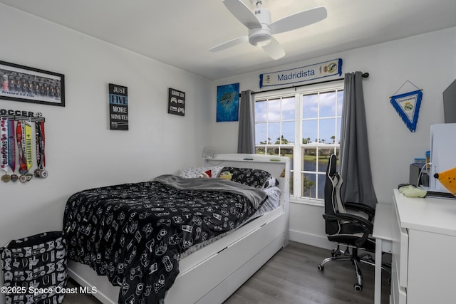 bedroom featuring baseboards, wood finished floors, and ceiling fan