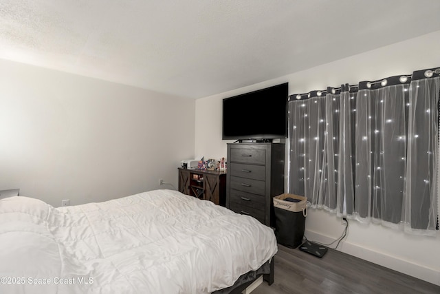 bedroom with baseboards and wood finished floors