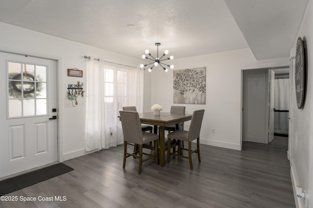 dining room featuring dark wood finished floors, baseboards, and a chandelier
