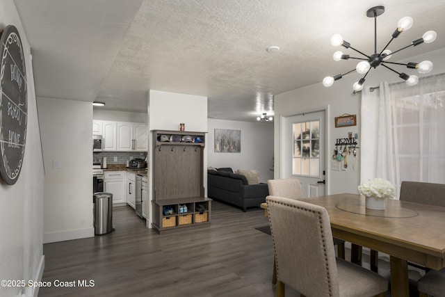 dining area with dark wood finished floors, a textured ceiling, baseboards, and a chandelier