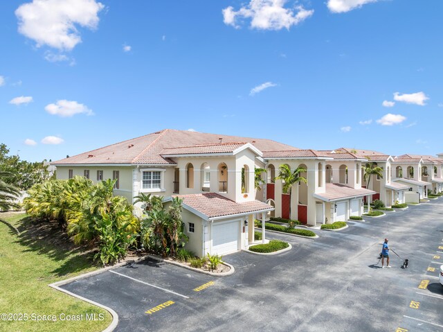 129 Lancha Cir Unit 201, Indian Harbour Beach, FL 32937 - view of building exterior with uncovered parking and a residential view