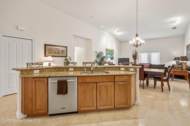 129 Lancha Cir Unit 201, Indian Harbour Beach, FL 32937 - kitchen with dishwasher, light stone counters, a sink, open floor plan, and brown cabinetry