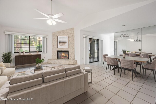 787 Greenwood Manor Cir Unit 14, West Melbourne, FL 32904 - living area featuring a fireplace, vaulted ceiling, light tile patterned floors, and ceiling fan with notable chandelier