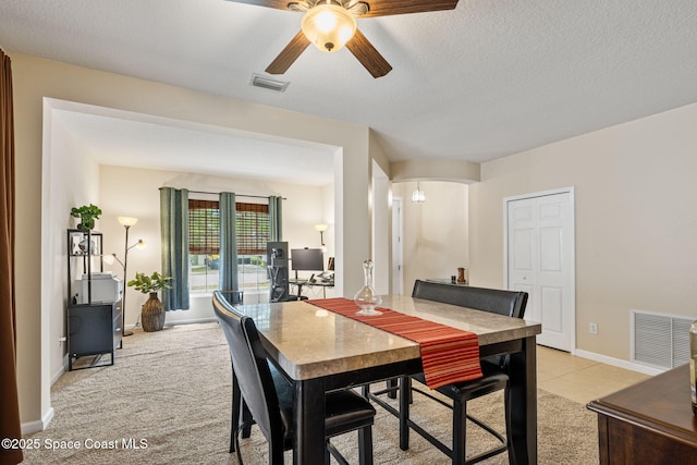3666 Mount Carmel Ln, Melbourne, FL 32901 - dining area with ceiling fan, light carpet, arched walkways, baseboards, and a textured ceiling