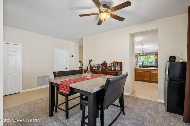 3666 Mount Carmel Ln, Melbourne, FL 32901 - dining room with light tile patterned flooring, light colored carpet, a ceiling fan, and baseboards