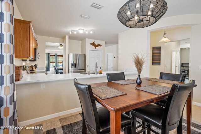 3666 Mount Carmel Ln, Melbourne, FL 32901 - dining room featuring a ceiling fan, a chandelier, baseboards, and light colored carpet