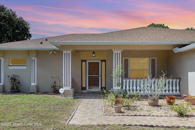 2298 Mantilla Ave SE, Palm Bay, FL 32909 - view of front of home featuring covered porch, stucco siding, a shingled roof, and a front lawn