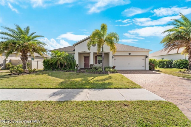 mediterranean / spanish-style home featuring an attached garage, stucco siding, a front yard, and decorative driveway