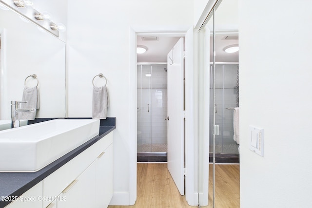 6365 Bahia Del Mar Blvd S Unit 210, Saint Petersburg, FL 33710 - full bathroom with visible vents, wood finished floors, a stall shower, and vanity