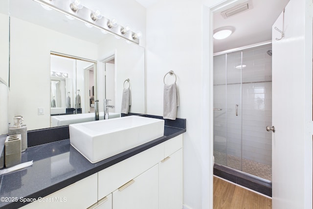 6365 Bahia Del Mar Blvd S Unit 210, Saint Petersburg, FL 33710 - bathroom with a stall shower, visible vents, wood finished floors, and vanity