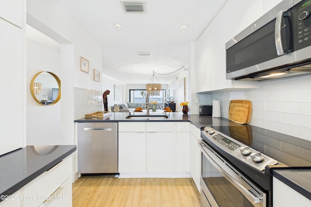 6365 Bahia Del Mar Blvd S Unit 210, Saint Petersburg, FL 33710 - kitchen with white cabinets, visible vents, and appliances with stainless steel finishes