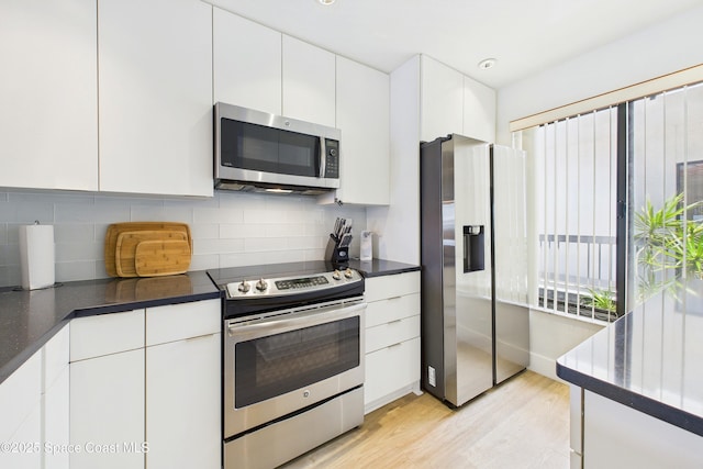 6365 Bahia Del Mar Blvd S Unit 210, Saint Petersburg, FL 33710 - kitchen featuring backsplash, white cabinets, dark countertops, and appliances with stainless steel finishes